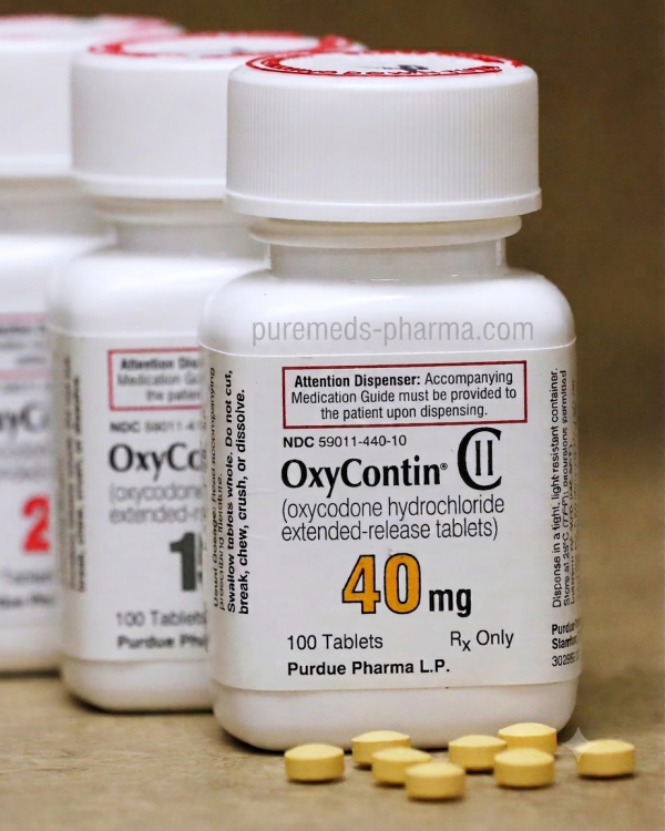 OxyContin 40mg Bottles and Tablets: Understanding How Long Does OxyContin Stay in Your System? Close-up photograph of two prescription bottles of OxyContin 40mg (oxycodone hydrochloride extended-release) and loose yellow tablets, illustrating the medication relevant to questions about detection time and how long does oxycontin stay in your system.